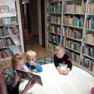 Dzieci słuchające jak Pani Bibliotekarka czyta książkę