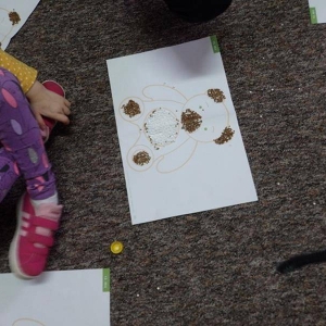 Dzieci wykonują pracę plastyczną-  z kaszy, ryżu i sztucznego śniegu tworzą obrazek misia